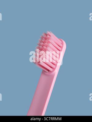 Pink toothbrush on blue background. Closeup Stock Photo