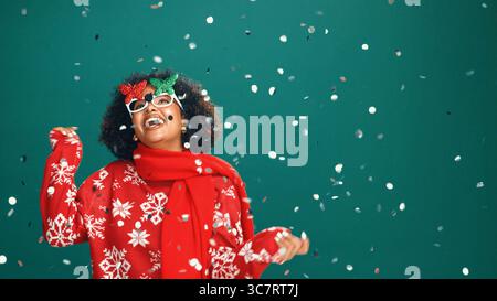 Confetti, Christmas and woman in studio dance for party, festive season and holiday. Mockup space, December and person with decoration, glitter and Stock Photo