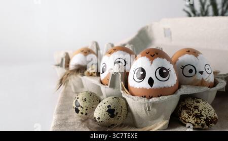 Funny owls. Brown Easter eggs in egg packs. Easter decorations. Stock Photo