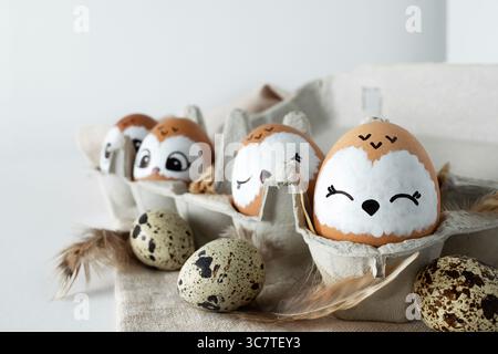 Family of owls. Brown Easter eggs in egg packs. Easter decorations. Stock Photo