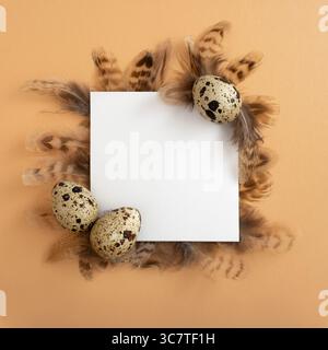 Easter frame. Easter quail eggs, square white paper on beige background. Flat layout, top view, copy space. Happy Easter card. Stock Photo
