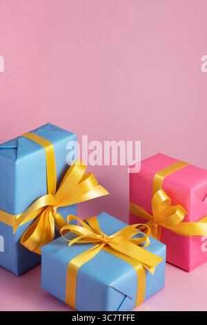 Blue and pink gift boxes with yellow ribbons on a pink background. Space for your text. Stock Photo