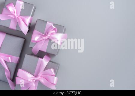 Banner with gray gift boxes with pink ribbon on a light gray background. Space for your text. Stock Photo