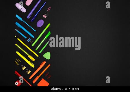 Creative layout made of neon colorful stationery set on black background. Place for your text Stock Photo