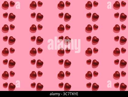 Pattern with pairs of red glittery hearts on pink background. Valentine's Day Backdrop Stock Photo