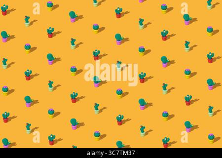 Pattern of toy green cacti on a bright yellow background Stock Photo