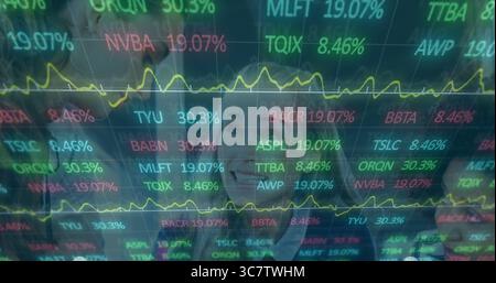Finance analysts in suits analyzing in office with transparent screen showing stock tickers, graphs Stock Photo