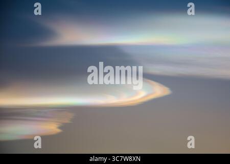 Rainbow clouds during sunset, iridescent clouds, are a colorful optical phenomenon that occurs when sunlight interacts with water droplets Stock Photo