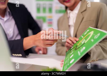 Asian Business Professionals Collaborating on Strategic Project in Modern Office Analyzing Data Stock Photo