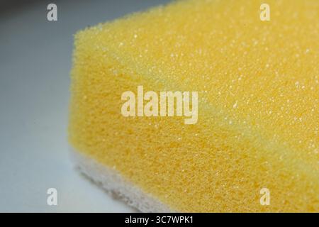 Detailed macro shot of a yellow sponge, emphasizing its unique texture and pattern, with a focus on the porous material and soft surface for cleaning Stock Photo
