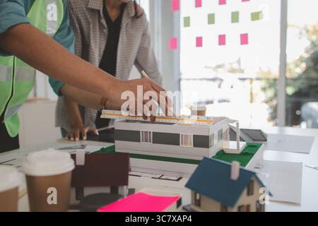 architects and engineers are discussing the design and structure of the upcoming building with the foreman to ensure that they understand the details Stock Photo