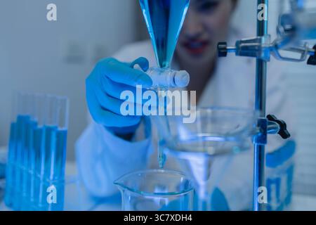 two scientists consult each other while conducting an experiment on a liquid substance in a laboratory, the two chemists exchange experimental data to Stock Photo