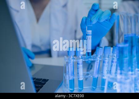 two scientists consult each other while conducting an experiment on a liquid substance in a laboratory, the two chemists exchange experimental data to Stock Photo