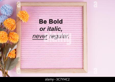 Top view of pink frame with inspirational quotes Be bold or italic, never regular Stock Photo
