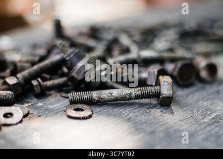 An old bolt in mazut with a blurred background and a place for text. Stock Photo