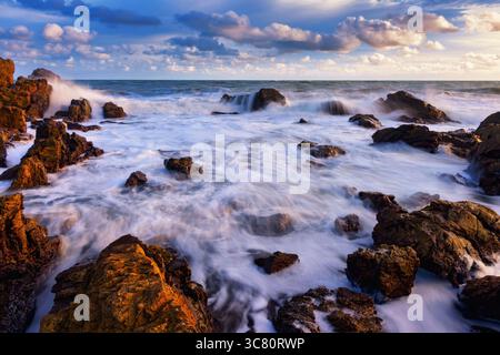 Waves crashing over coastal rocks on a tropical beach, Vietnam Stock Photo