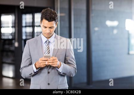 Modern office corridor featuring glass partitions and brick wall under lights, copy space Stock Photo