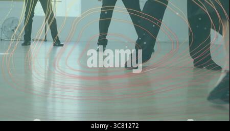 Practicing dancers in black dance shoes coordinating footwork in studio, with fan and digital lines Stock Photo