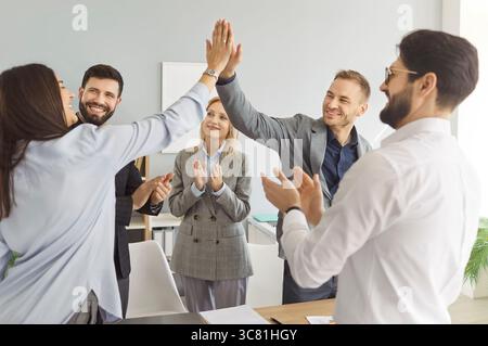 Happy friendly diverse employees common high five congratulating with business achievement Stock Photo