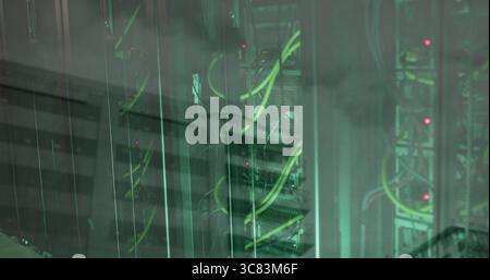 Showing glass-enclosed server rack with network switches, neon green cables and LEDs in data center Stock Photo