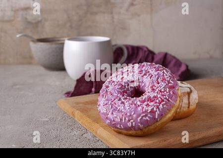 Pink and white donuts on a wooden board, place for text Stock Photo