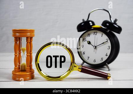 OTP abbreviation of One Time Password text with alarm clock on wooden background Stock Photo