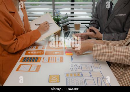 the development team is consulting on the design of the website UX UI, they are working on project of ux ui, interface, innovation of ux ui, develop t Stock Photo