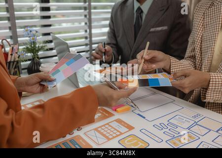 the development team is consulting on the design of the website UX UI, they are working on project of ux ui, interface, innovation of ux ui, develop t Stock Photo