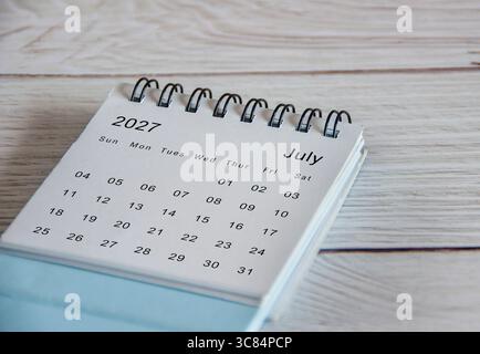 Close up of July 2027 calendar on wooden background. Stock Photo