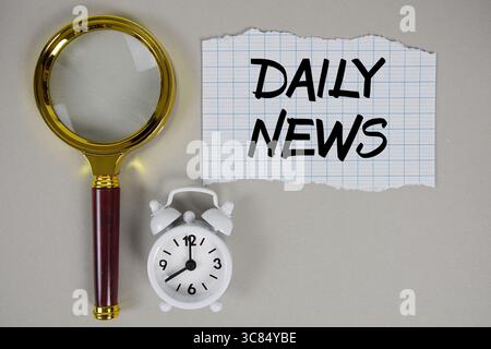 Daily News text written on paper with magnifying glass and alarm clock Stock Photo