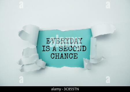 Everyday Is A Second Chance message written on blue paper with torn paper background Stock Photo