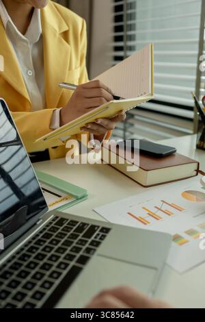Two colleagues spend most of their time at workplace to meet deadlines, meeting between businessmen discussing first quarter sales, two employees work Stock Photo