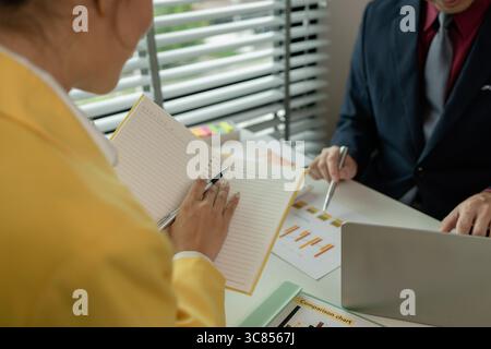 Two colleagues spend most of their time at workplace to meet deadlines, meeting between businessmen discussing first quarter sales, two employees work Stock Photo