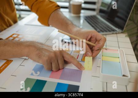 A web designer is using his idea to create a digital product design project that will meet the needs of users in terms of both appearance and feel whe Stock Photo