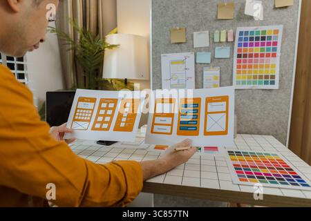 A web developer, as a User Experience and User Interface Officer, is designing beautiful and easy-to-use digital products that create a positive emoti Stock Photo