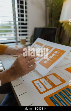 A web developer, as a User Experience and User Interface Officer, is designing beautiful and easy-to-use digital products that create a positive emoti Stock Photo