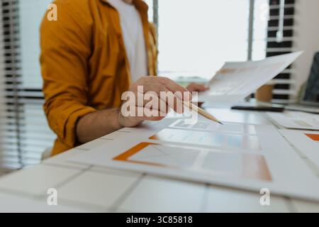 A web developer, as a User Experience and User Interface Officer, is designing beautiful and easy-to-use digital products that create a positive emoti Stock Photo