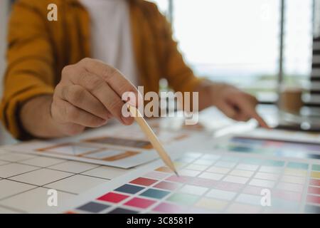 A web designer is using his idea to create a digital product design project that will meet the needs of users in terms of both appearance and feel whe Stock Photo