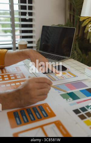 A web designer is using his idea to create a digital product design project that will meet the needs of users in terms of both appearance and feel whe Stock Photo