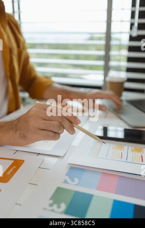 A web designer is using his idea to create a digital product design project that will meet the needs of users in terms of both appearance and feel whe Stock Photo