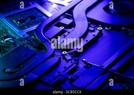 Close-Up of Laptop Cooling Heatpipes and Internal Components Under Intense Blue and Purple Accent Lighting Stock Photo