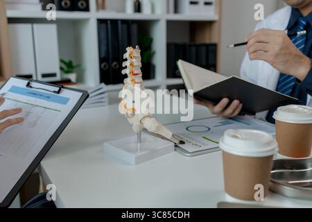 two surgeons are sitting in a private office at a hospital discussing an upcoming major pelvic surgery, there was a discussion between the two doctors Stock Photo
