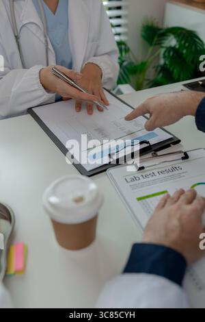 two doctors sat in a private office at the hospital discussing and exchanging knowledge with each other, doctors discussed the way that would be the m Stock Photo