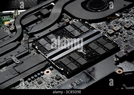 Close-Up of Laptop Motherboard with RAM Modules, Cooling System, and Detailed PCB Circuitry in Focus Stock Photo