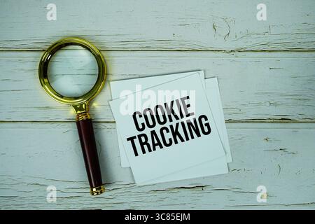 Cookie Tracking text message on paper with magnifying glass on wooden background Stock Photo