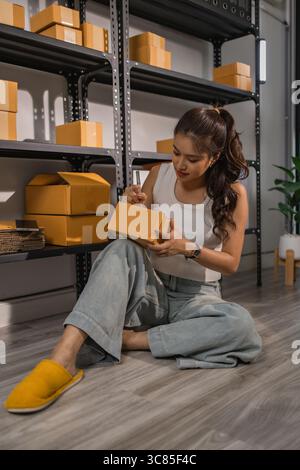 warehouse worker is checking boxes of packaged in the warehouse, a small business owner who runs an online business is packing packages to send to cus Stock Photo