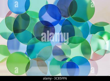 3D rendering of Overlapping Transparent Green and Blue Glass Discs Creating Soft Abstract Patterns on a Light Background Stock Photo