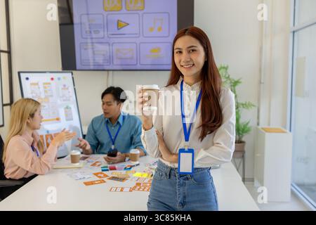 ux, ui, mobile application designer looks at the camera, web designer looks at the camera, working environment in the office of the web and mobile app Stock Photo