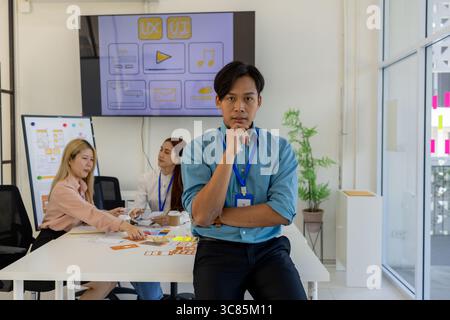 ux, ui, mobile application designer looks at the camera, web designer looks at the camera, working environment in the office of the web and mobile app Stock Photo