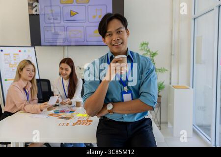 ux, ui, mobile application designer looks at the camera, web designer looks at the camera, working environment in the office of the web and mobile app Stock Photo